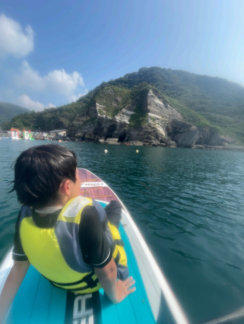 子供がカヌーに乗って景色を眺めている写真